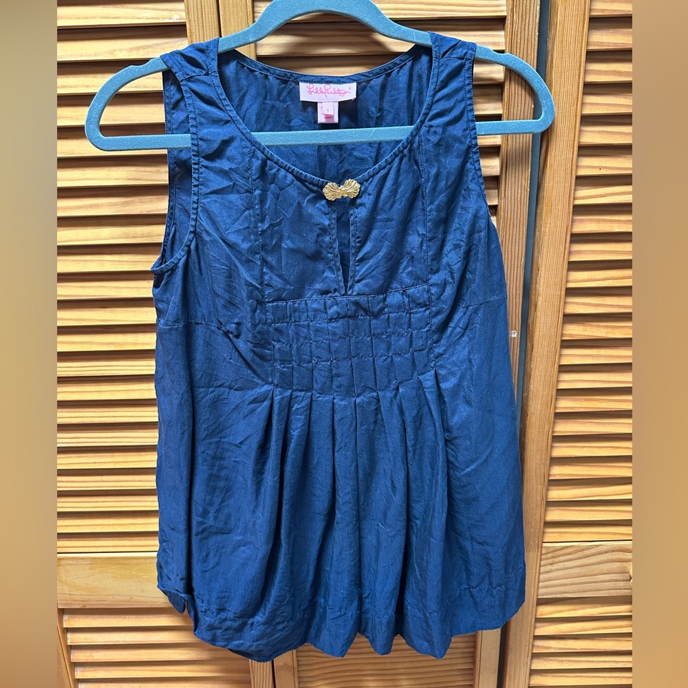 Lily Pulitzer blue sleeveless top with gold button in front.